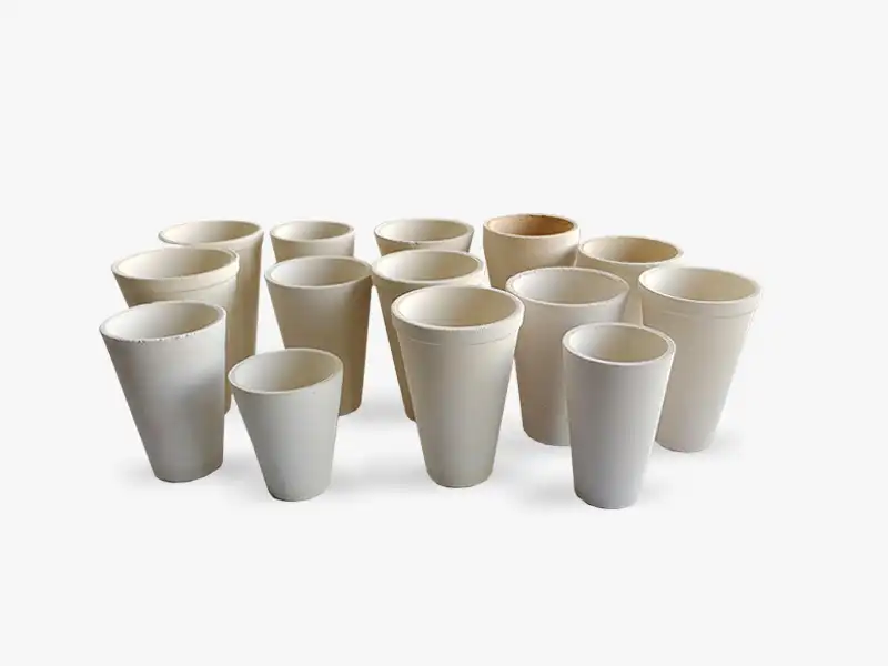 A collection of DECENT fire assay clay crucibles of different sizes, arranged on a white background.
