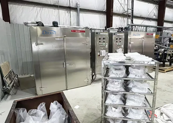 Two large stainless steel DECENT DDO-2-4-5000N industrial drying ovens with control panels and a trolley of bagged samples in a Canadian laboratory setting.