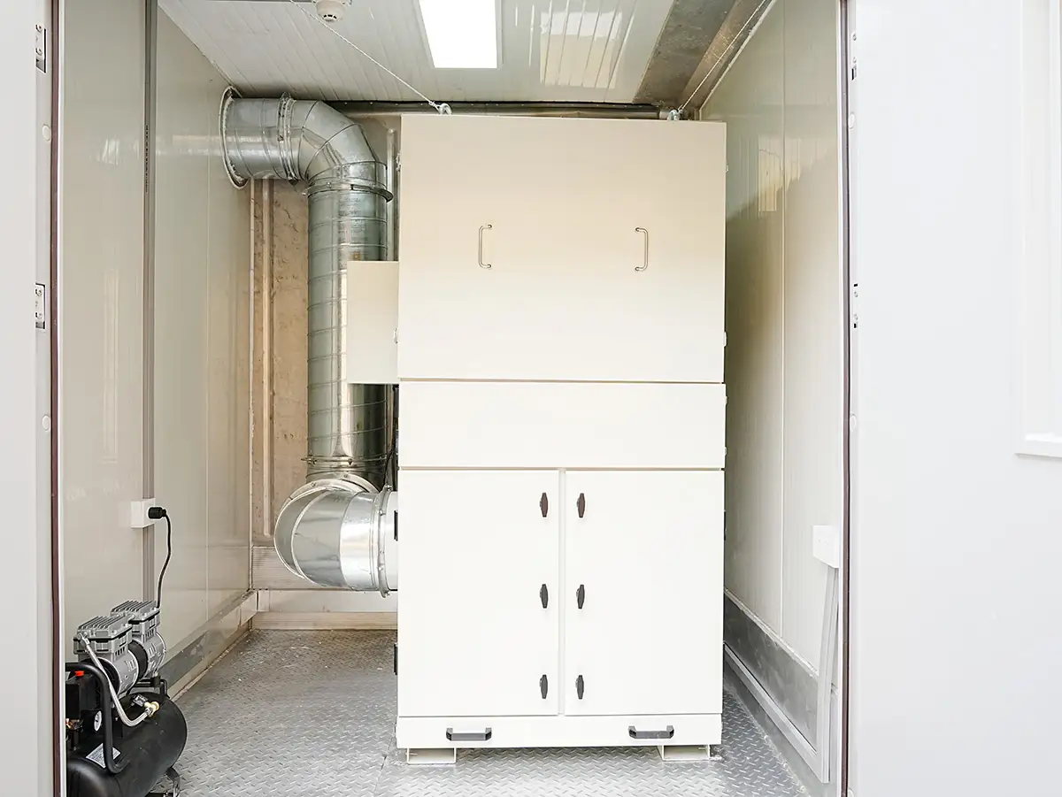 2025 Container Laboratory Triumph: DECENT Mexican Project Sets New Global Benchmark 7 White dust removal filtrater unit with silver ventilation ducts and an air compressor inside a DECENT (Qingdao Decent Group) container laboratory.