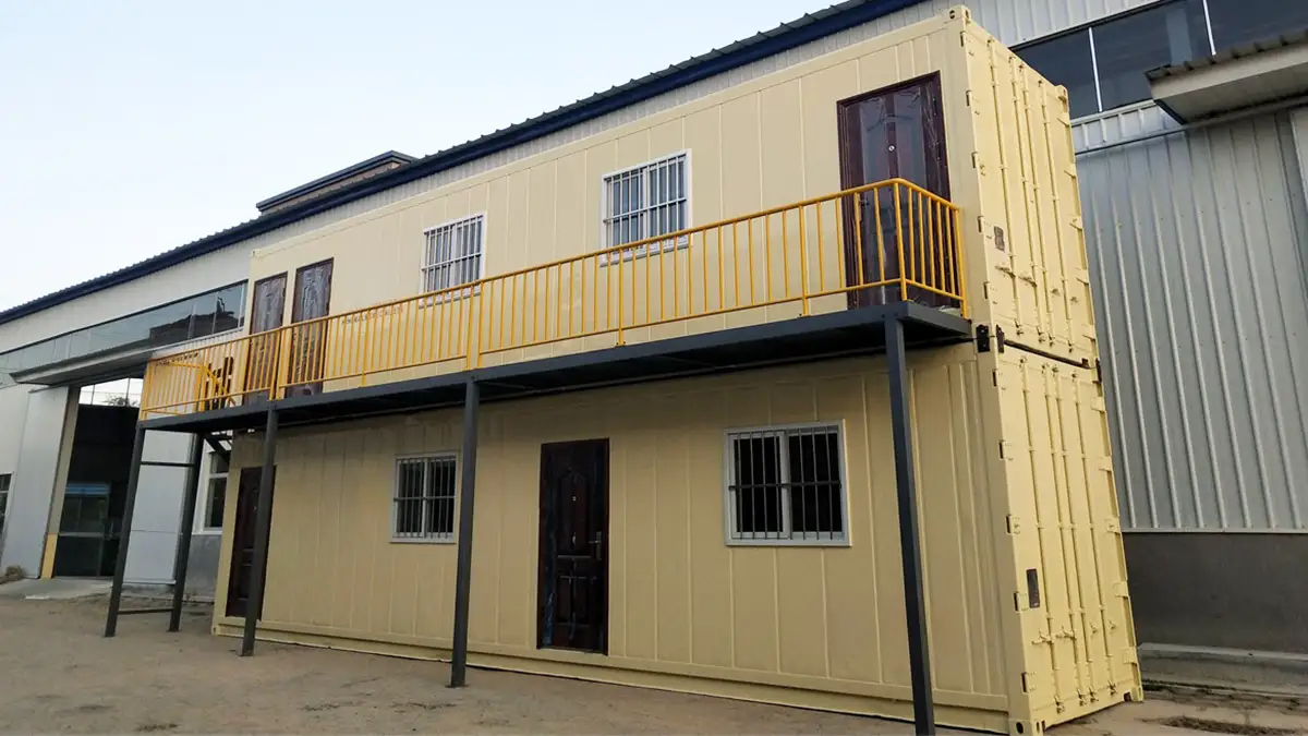 Two-story modular container building by Qingdao Decent Group, cream-colored with yellow balcony, suitable for Chile Container Laboratories or portable offices.