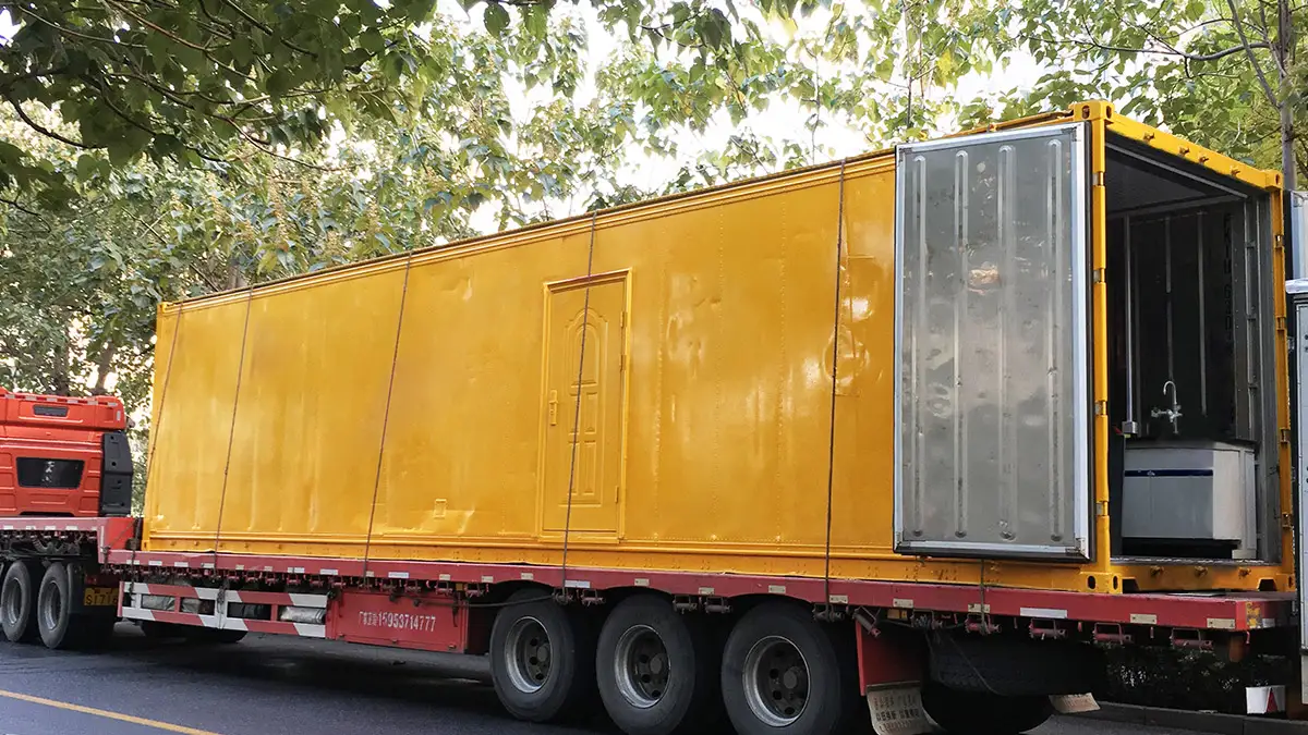 A yellow containerized laboratory on a truck, ready for delivery for the China Containerized Laboratory Project.