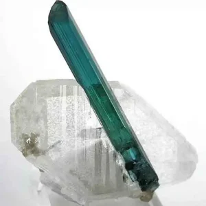 5 Stunning The Minerals Types That Will Amaze You - Nature's Hidden Treasures 10 A single, long, prismatic crystal of translucent blue tourmaline, also known as electric stone or indicolite, perched on a clear quartz crystal.