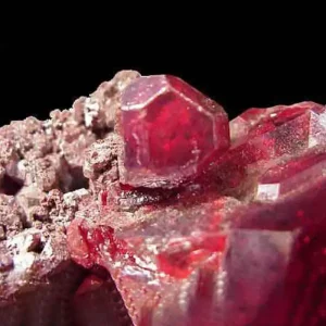 5 Stunning The Minerals Types That Will Amaze You - Nature's Hidden Treasures 20 A beautiful close-up of a cluster of deep red, translucent cuprite crystals, also known as red copper ore, on a dark matrix.
