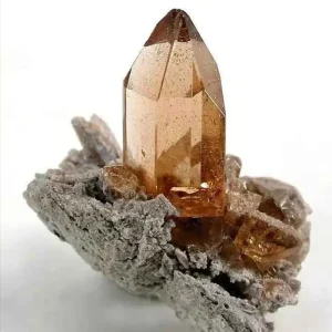 5 Stunning The Minerals Types That Will Amaze You - Nature's Hidden Treasures 14 A beautiful, large, golden-brown topaz crystal, a silicate mineral also known as a 'topa stone', growing out of a gray, rough rock matrix.