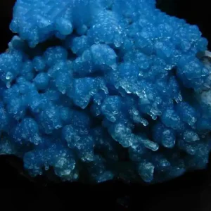 5 Stunning The Minerals Types That Will Amaze You - Nature's Hidden Treasures 23 A vibrant blue mineral specimen of gibbsite, an aluminium hydroxide, with a unique botryoidal or grape-like texture on a dark matrix.
