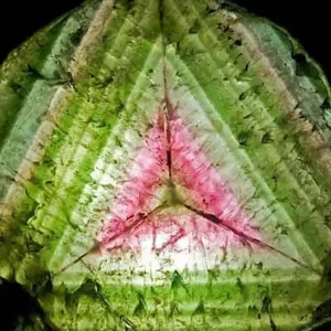 5 Stunning The Minerals Types That Will Amaze You - Nature's Hidden Treasures 9 A close-up of a vibrant watermelon tourmaline slice, showing distinct concentric rings of green and pink colors, resembling a watermelon.