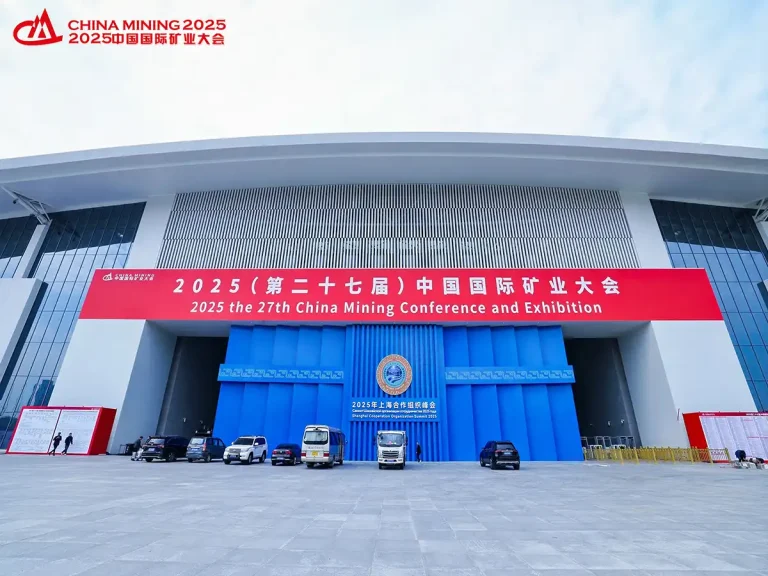 Wide shot of the modern exterior of the 2025 China Mining Conference and Exhibition venue, with a large red banner over the entrance.