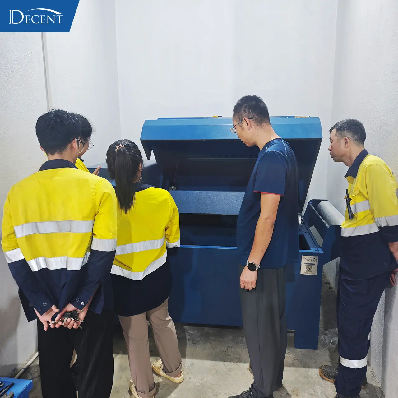 Qingdao Decent Group engineering team conducts crucible tumbler operational walkthrough for client staff at Laos fire‑assay lab for turnkey mineral laboratory construction